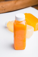 Close up photo of fresh orange juice bottle on table.