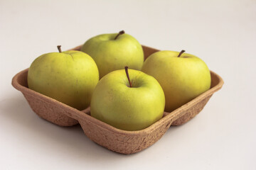 Fresh green apples on biodegradable pulp paper food tray isolated on white. Recyclable packaging concept.  Side view, copy space