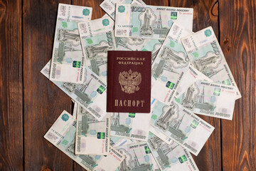 Russian passport with money for shopping abroad, travel and entertainment. Money is lying on wooden background.