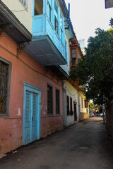 Old traditional houses in a narrow street in Old Town, Antalya, Turkey. Blue wooden door and bay window of house. 
