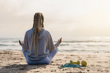Yoga, mindfulness, healthy lifestyle concept - Young african fit woman meditating outdoors on the...