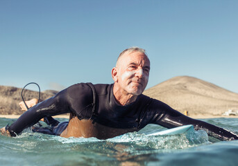 Mature man surfing in the sea - 410913729