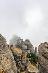 gray rocks on top of a mountain in fog on an autumn day