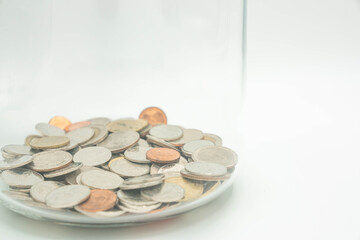 Thai coin bath in glass jar on white background. Saving money concept.