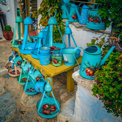 A collection of Traditional Greek Painted watering cans and planters.