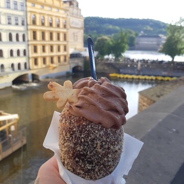 Delicious Prague ice-cream against the background of architecture houses and the Czech river.