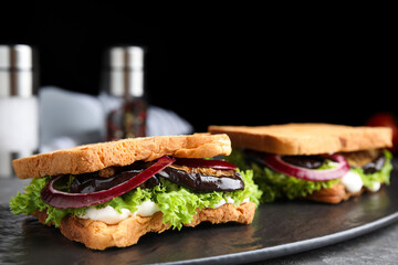 Delicious eggplant sandwiches on slate board, closeup