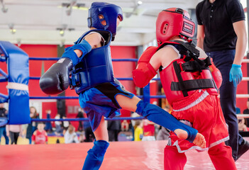 Fototapeta premium boxers in the ring. Boxer in full gear. Children's sports. Thai boxing. Boxing competition. Kick.