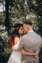 Walking the bride and groom outdoors. Beautiful summer photo session in nature.