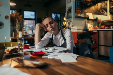 overworked manager dealing with finances in her restaurant