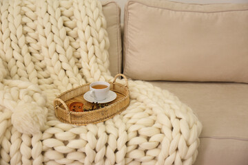 Obraz premium Tray with cup of tea on white knitted blanket. Interior element