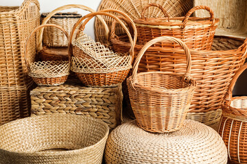 Many different wicker baskets made of natural material as background, closeup