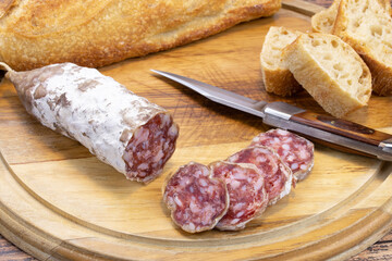 saucisson sec et baguette de pain sur une planche à découper