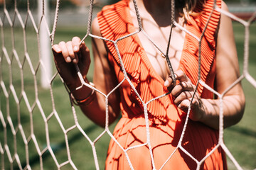 woman in red holding a soccer goal net