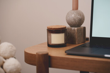 Decorative objects candle in the room in boho interior and laptop