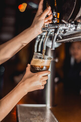 bartender pouring beer in bar