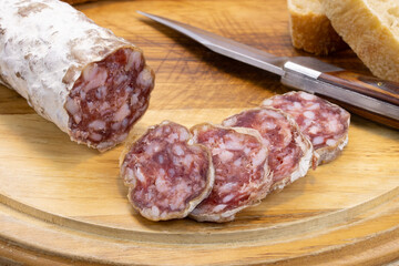 saucisson sec et baguette de pain sur une planche à découper