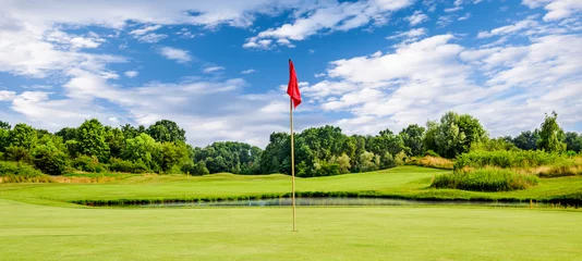 Fotobehang Golf course on a summer day with a flag, green golf with red flag © trattieritratti