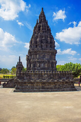 Fototapeta premium Prambanan Hindu temple view, green grass field foreground and blue sky near Yogyakarta, Java island, Indonesia