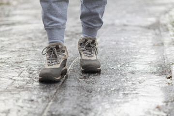 A pedestrian walks along a dangerous icy sidewalk. Frozen rain.