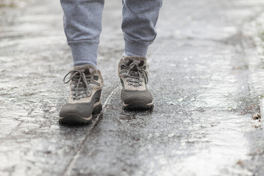 A Pedestrian Walks Along A Dangerous Icy Sidewalk. Frozen Rain.