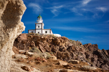 Fototapeta na wymiar 19th-century lighthouse - Akrotiri Lighthouse - on rocky hill on Santorini Island, Greece, Cyclades. Famous landmark in Akrotiri village