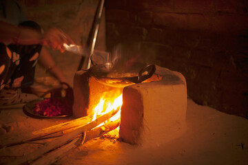An earthen stove with wooden fire in a village.