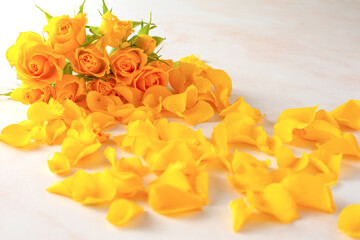 bouquet of yellow roses and petals on the floor.