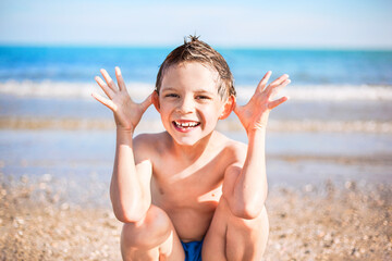 smiling boy sitting on the beach