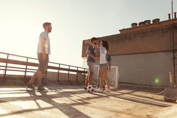People warming up before playing football on a building rooftop terrace