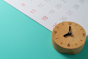 close up of calendar and alarm clock on the green table background, planning for business meeting...