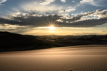 Sunburst Over Layers of Sand Dunes