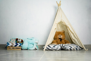 White room with teepee and baby's toys