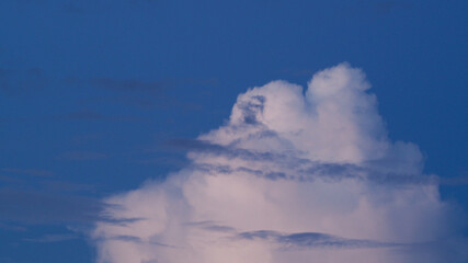 Vue rapprochée sur le sommet d'un gros Cumulus, pendant l'heure bleu.  Le nuage apparait ainsi beige / rosé