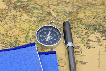 Classic round compass on background of old vintage map of world as symbol of tourism with compass, travel with compass and outdoor activities with compass
