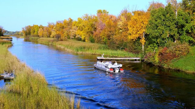Mississippi River and a pontoon in Bemidji Minnesota near highway 2. Beautiful autumn colors in the trees along the river, a few miles from the source at Lake Itasca.