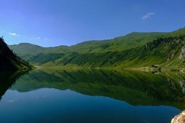 Fototapeta na wymiar mountain lake with wonderful reflection from the mountains and blue sky