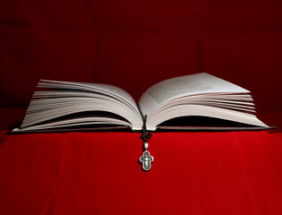 open holy bible and cross on red background