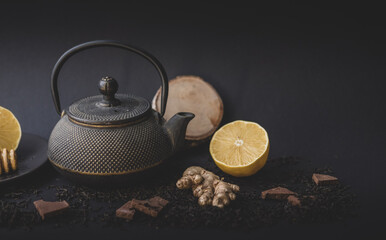 tea ceremony . lemon tea honey teapot on black background. copy space.