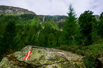 sign from austria on a rock in green mountains in the summer