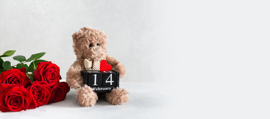 St Valentine's Day banner. Cute teddy bear holding wooden calendar with the date14 february and red roses bouquet on white background. Romantic gift, festive sale, greeting card, web line. Copy space