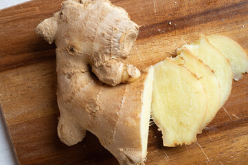 Fototapeta premium cutting fresh ginger spice at wooden desk. Healthy concept