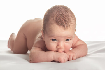 Naked cute caucasian infant posing naked on the white background.