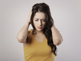 Stressed unhappy casual woman with headache closed ears the hands because not want the hear any...