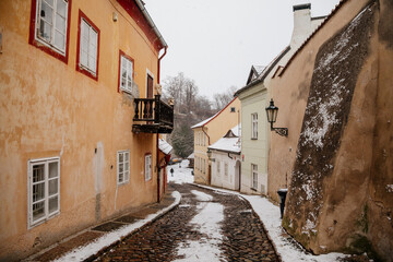 Fascinating narrow picturesque street with baroque and renaissance historical buildings, snow in winter day, Novy svet, New World in vicinity of Hradcany, Prague, Czech Republic