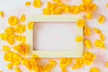 Yellow rose petals with wooden frame.