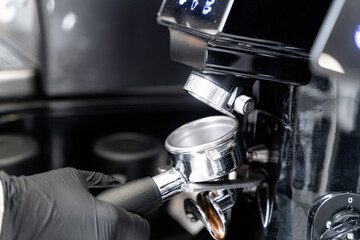 Barista makes coffee. Coffee horn by the coffee machine. The coffee is poured into the coffee horn.