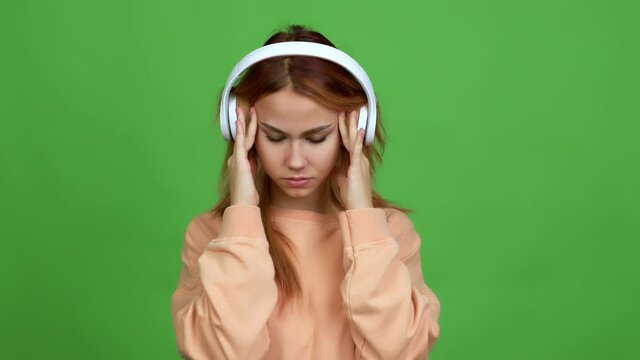 Teenager girl listening music with headphones unhappy and frustrated with something over isolated background