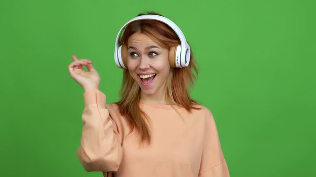 Teenager girl listening music with headphones intending to realizes the solution while lifting a finger up over isolated background