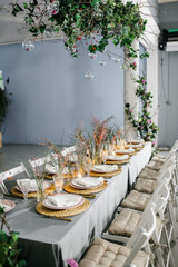 decorated with fresh flowers and served table for a festive dinner indoors